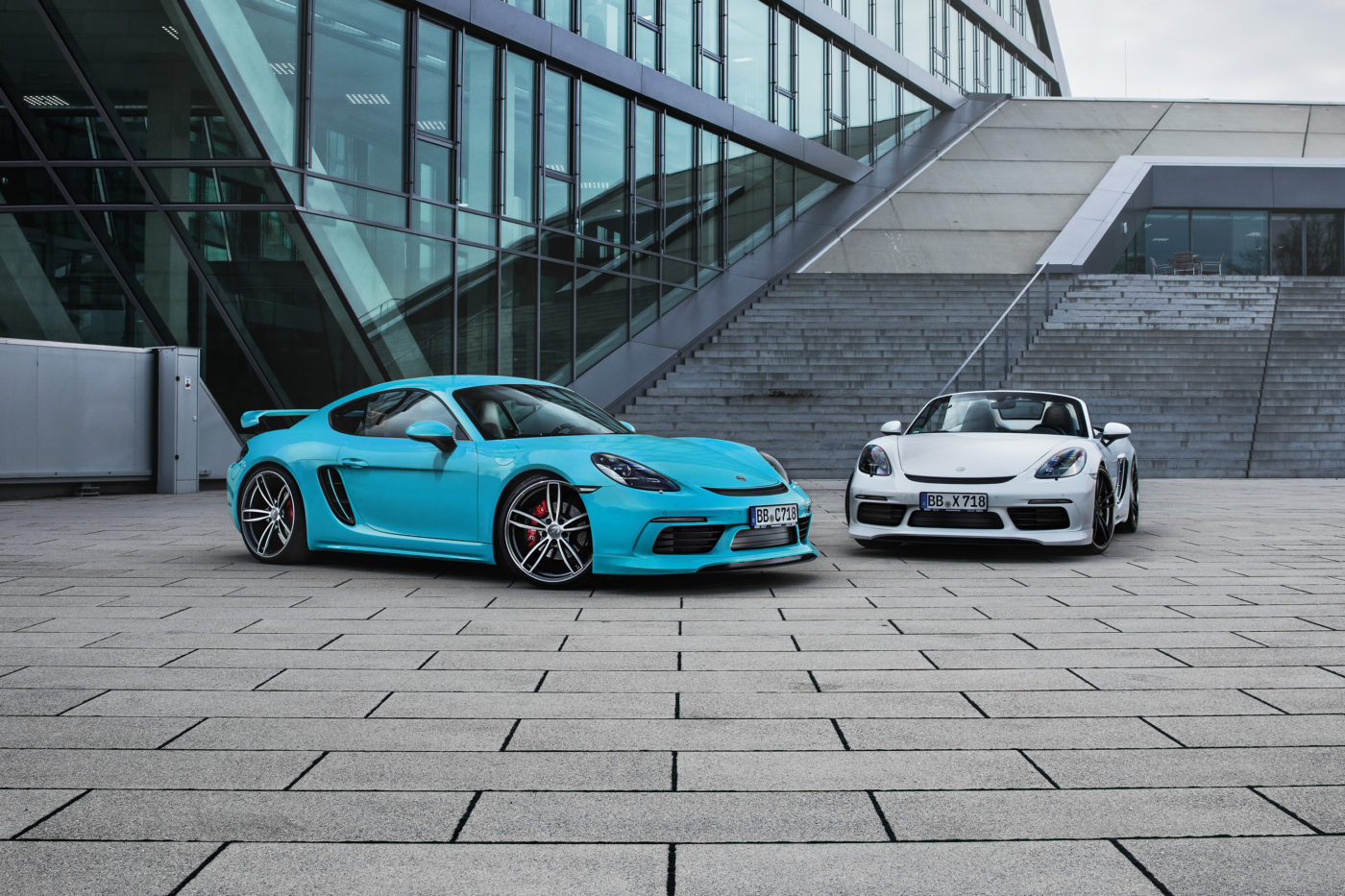 Porsche Cayman Boxster Techart Tuning, two vehicles in bright cyan and white.